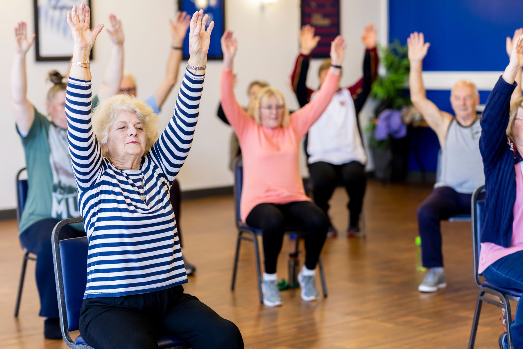 Older adults exercising together in a seated group class